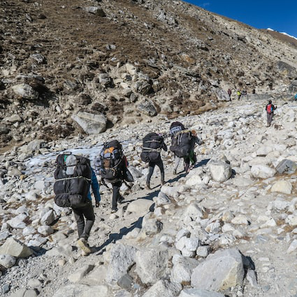 sherpas qui portent des sacs en haute montagne